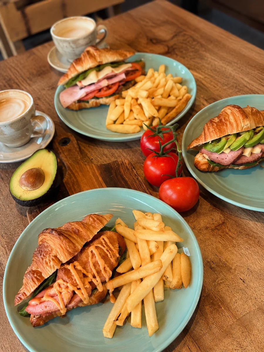 Brunch plates with sandwiches, chips and coffee